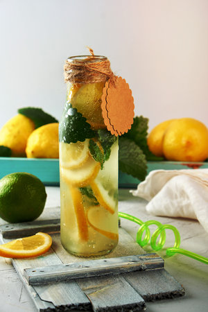soft drink lemonade in a glass bottle and ripe fresh lemons, white backgroundの写真素材