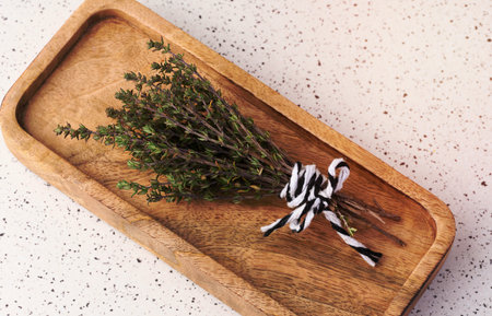 Sprigs of thyme tied with rope  on a wooden plate, top vewの写真素材