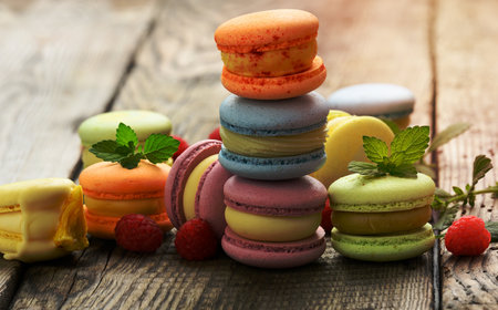 stack of baked multicolored macarons and different flavors on a gray wooden table, delicious dessert, close upの写真素材