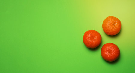 Three ripe mandarins on green background, top view. Ripe fruitの写真素材