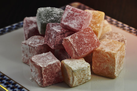 Square colorful Turkish sweets in powdered sugarの写真素材