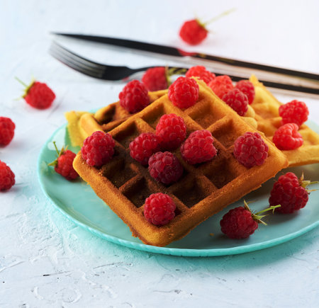 Stack of baked Belgian waffles with ripe red raspberryの写真素材