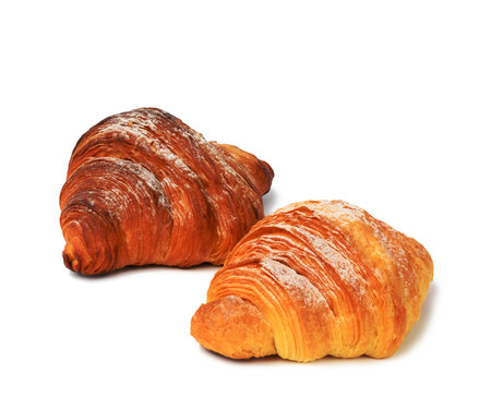 two baked croissants on a white isolated background, dessert for breakfast sprinkled with powdered sugarの写真素材
