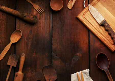 wooden kitchen vintage items: knife, rolling pin, empty spoons on brown wooden table, top view. Copy spaceの写真素材
