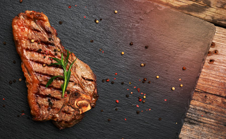 whole fried New York beef steak on a black board,  striploin doneness rare, top viewの写真素材