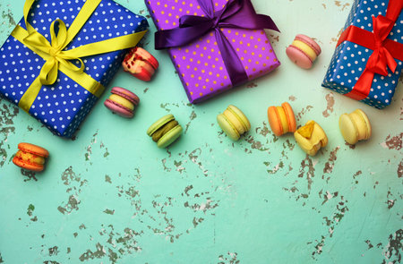 various gift boxes with tied bows and baked pasta on a green background, top viewの写真素材