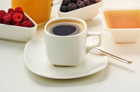 white ceramic cup with black coffee stands on a white table, breakfastの写真素材