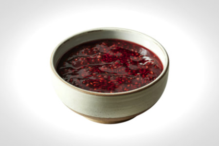 a bowl containing raspberries jam.