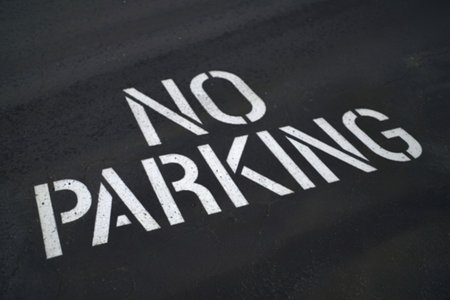 a dark asphalt surface with text NO PARKINGの写真素材