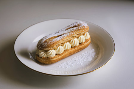 an eclair with vanilla cream on a white plateの写真素材