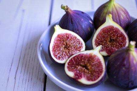 fresh figs arranged on a white ceramic plate