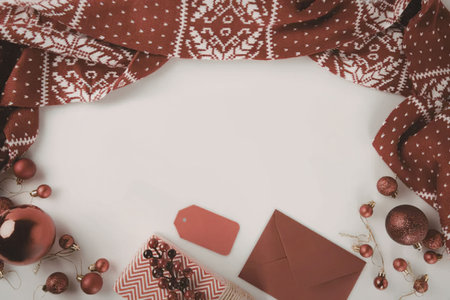 A festive arrangement of red and white Christmas decorations, including ornaments, gift boxes, and patterned fabric.の写真素材