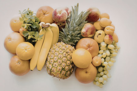 A vibrant arrangement of various fresh fruits including bananas, pineapple, and grapes.