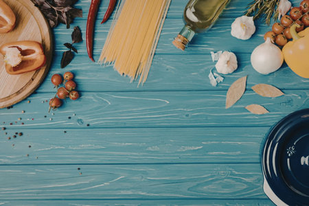 A variety of food ingredients, including vegetables, pasta, and spices, arranged on a blue wooden...