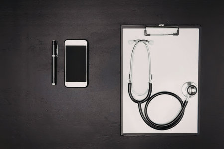 A stethoscope on a clipboard with a smartphone and pen