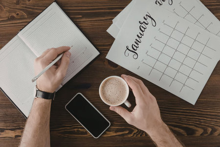 A person planning their January schedule with a cup of coffee