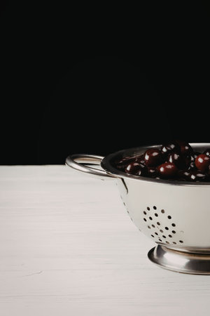 A metal colander with fruit on a white surfaceの写真素材