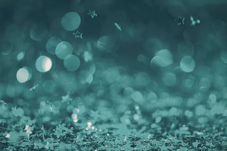 A teal-colored background with a bokeh effect and sparkling lights, creating a mesmerizing visual...
