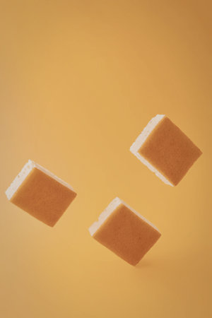 Three orange soap bars floating in mid-air against an orange background.