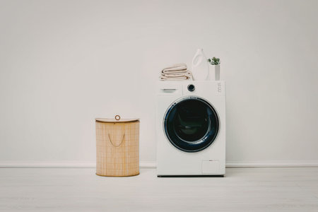 A washing machine and a laundry basket on a clean floor