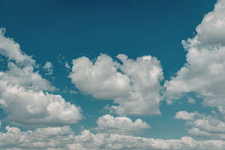 A clear blue sky with fluffy white clouds