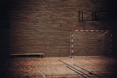 A dimly lit indoor sports court with a goal net
