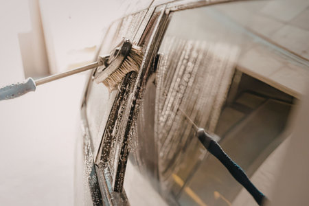 A car window being cleaned with a brush