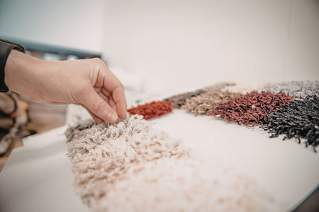 A hand selecting colorful fabric swatches
