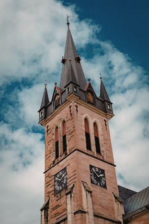 Clock tower stands against blue sky