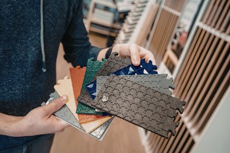 Man holding various flooring samples