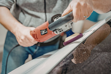 Man polishing car with electric buffer