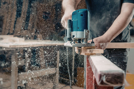 Man using power tool to cut wood