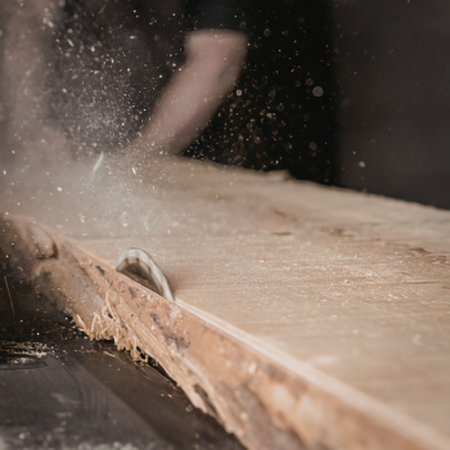 A person cutting wood in a workshop
