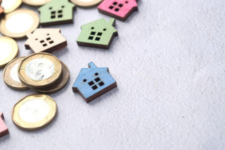 Colorful wooden house icons arranged beside golden euro coins.