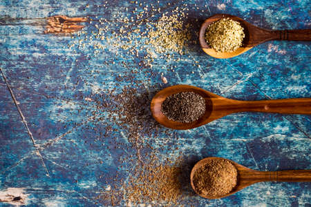 Flat lay view of wooden spoons filled with hemp seeds, chia seeds and ground flax seeds. Heart healthy super food concept.の写真素材