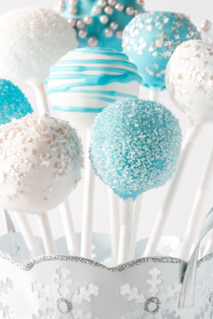 A close up of a bouquet of blue and white cake pops with different designs.の写真素材