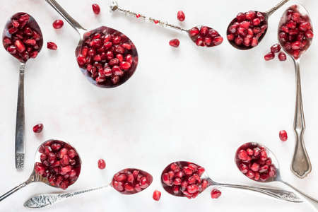 Spoons full of pomegranate arils.の写真素材