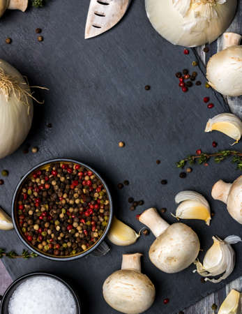 slate cutting board with salt and pepper and vegetables.の写真素材