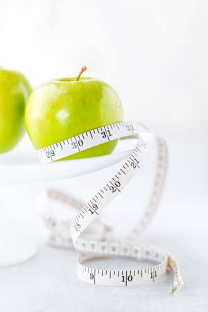 An apple with measuring tape.の写真素材