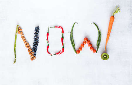 Healthy foods arranged to spell the word now.の写真素材