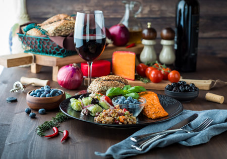 Mediterranean meal including greek salad, seven grain salad, blueberries and salmon. Served with red...