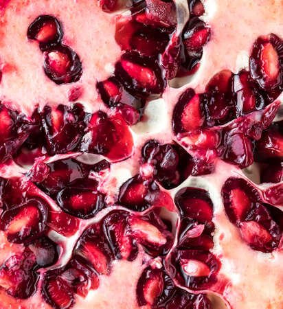 A macro close up of a pomegranate fruit sliced into.の写真素材