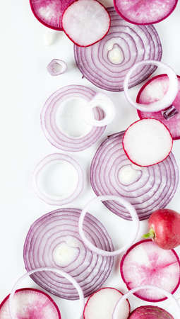 A top down view of a close up abstract arrangement of overlapping red onion slices along with daikon and radishes.の写真素材