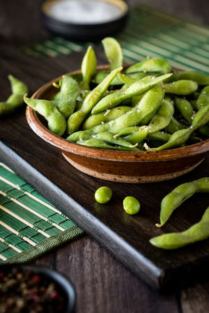 A close up of a rustic dish filled with edamame beans ready for eating.の写真素材