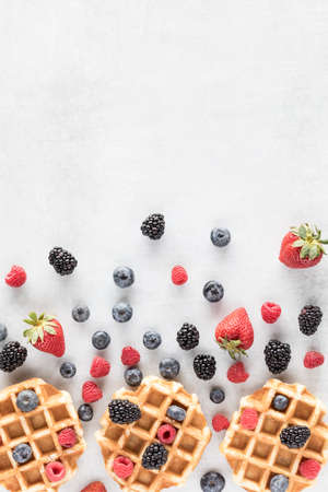 Top down view of Belgian waffles with berries in an abstract arrangement.の写真素材