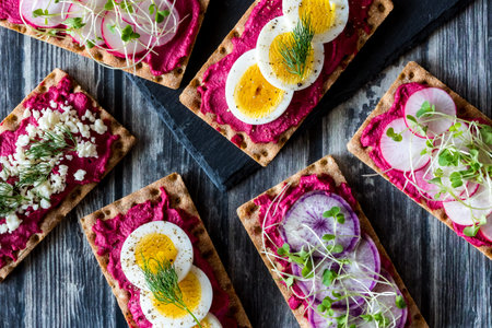 Top down view of an arrangement of rye wafer crackers with various toppings ready for snacking.