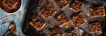 Top down view of caramel pecan chocolate chip squares on a sheet pan ready for eating.の写真素材