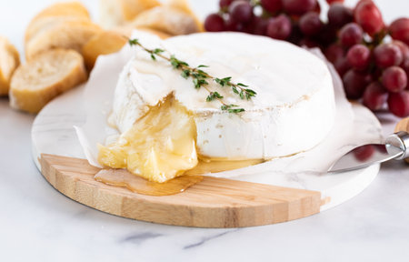 Baked brie served with grapes and crusty bread rounds.の写真素材