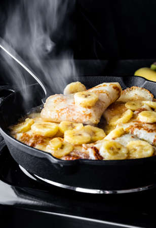Close up of delicious Banana Foster cooking and steaming in a cast iron skillet.の写真素材