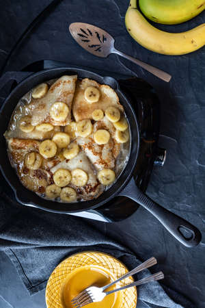 Top down view of Banana Foster with crepes cooking in a cast iron skillet.の写真素材